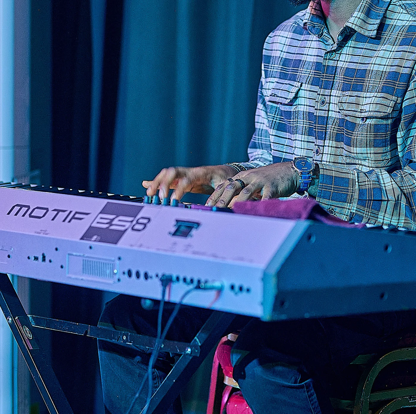 Mike Splendour playing a Yamaha Motif keyboard at a live performance.